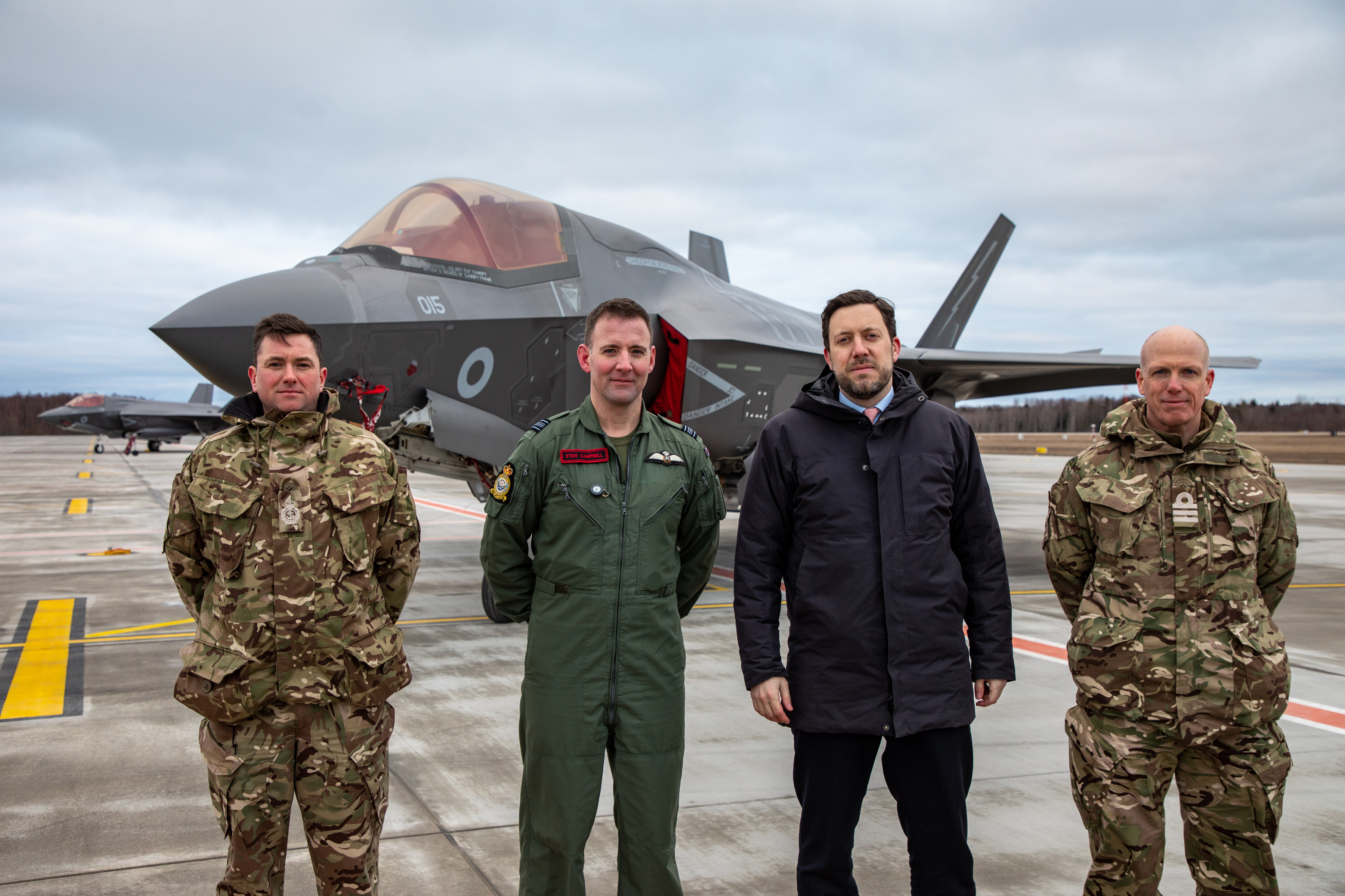 Personnel stand on the airfield before Lightning aircraft.